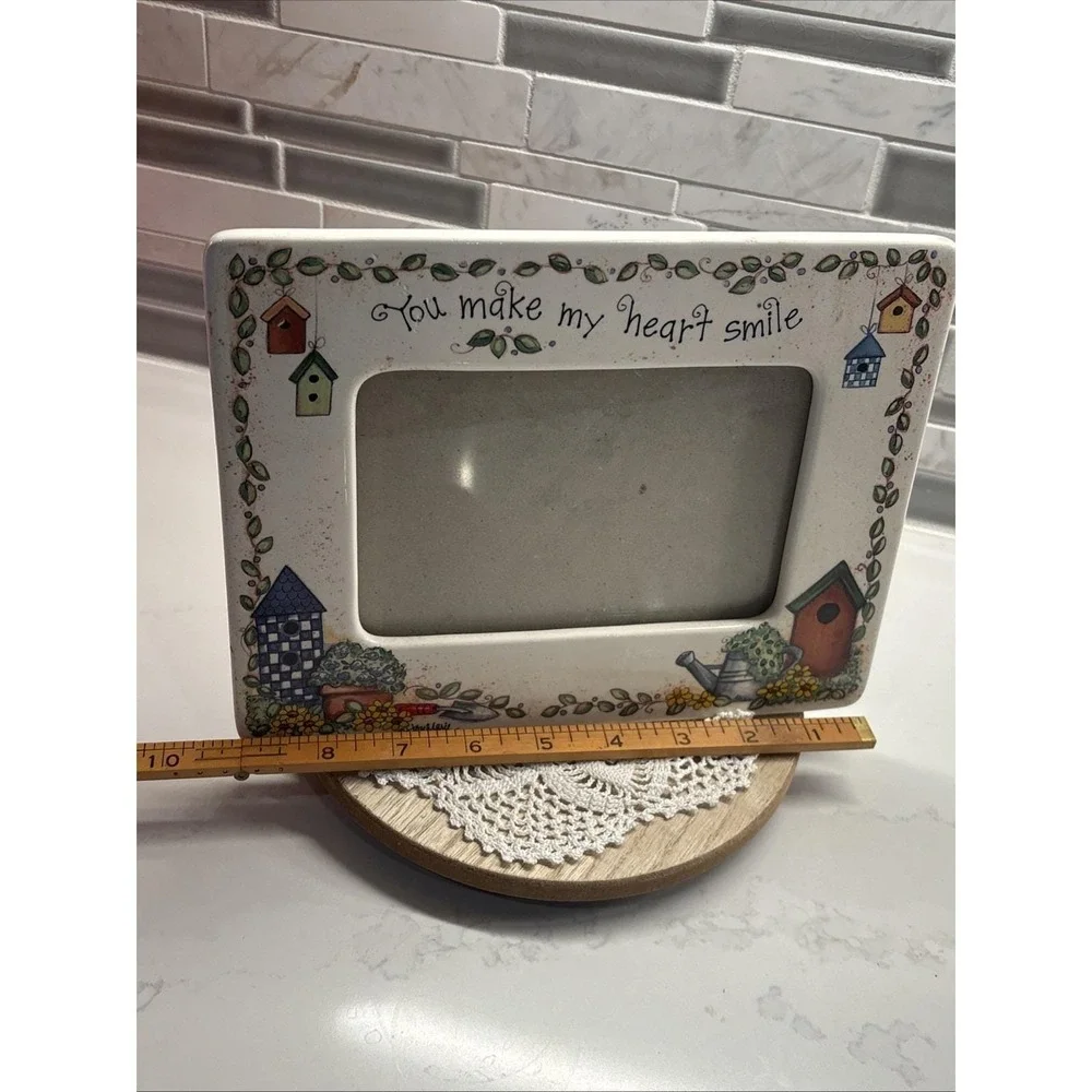 hand-painted ceramic picture frame featuring a garden theme with birdhouses.